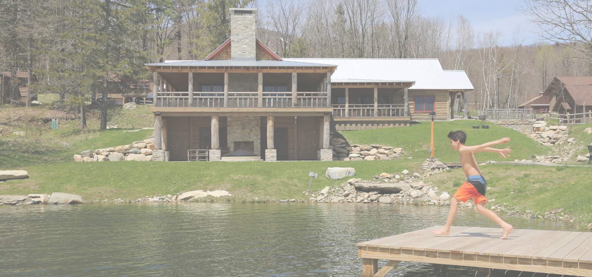 Seesaws Lodge - Summer Exterior with Boy on Dock jumping into pond