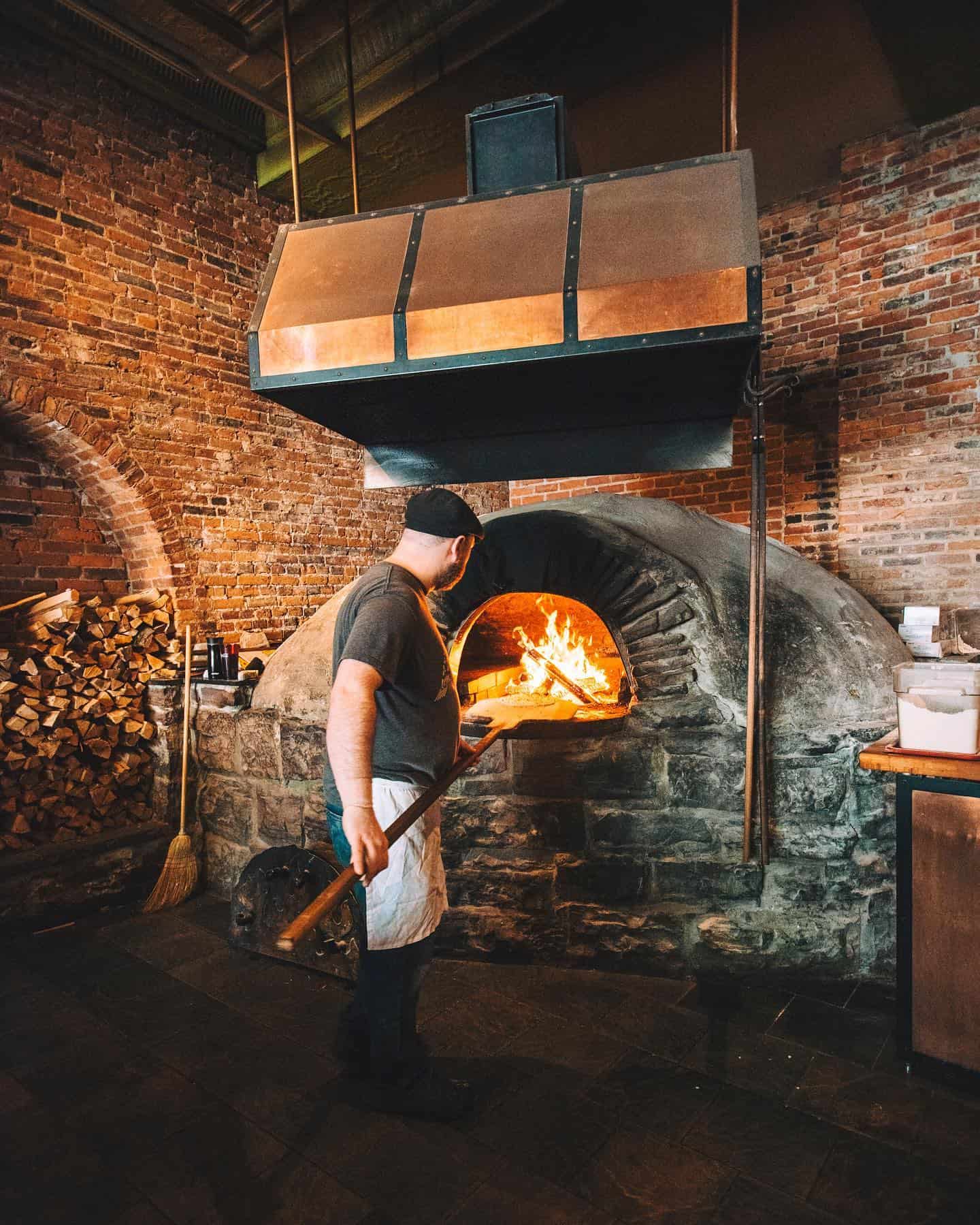 American Flatbread - Burlington Hearth - Chef Putting Pizza in Wood Fired Oven